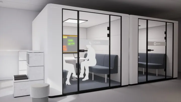 Zwei gläserne Meeting-Pods mit Sitzbänken und einem Display im Inneren